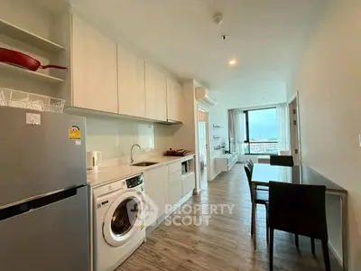 Modern open-layout kitchen and dining area with washing machine and scenic view.