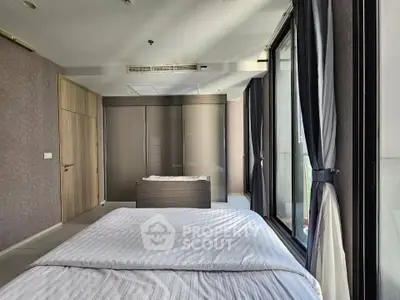 Spacious modern bedroom with large windows and elegant curtains, featuring a sleek design and ample natural light.