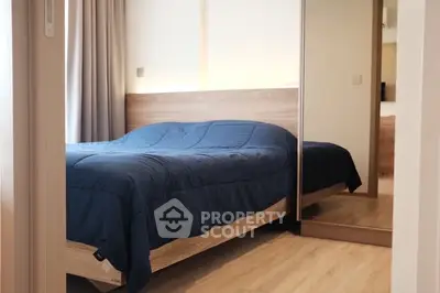 Modern bedroom with wooden flooring and mirrored wardrobe