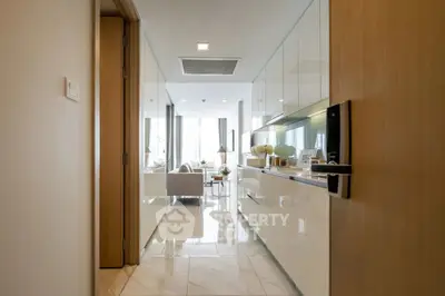 Modern open-layout kitchen with sleek cabinetry leading to a bright living area.