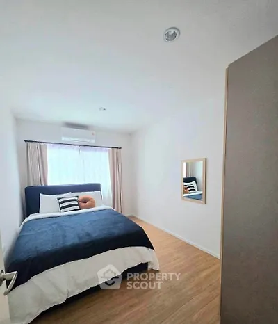Cozy bedroom with modern decor and natural light, featuring a comfortable bed and stylish wooden flooring.