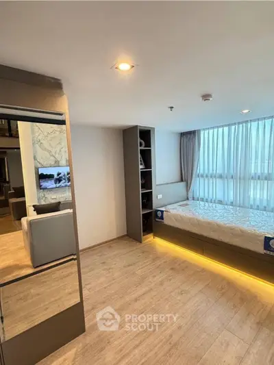 Modern bedroom with built-in storage and large window for natural light.