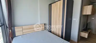 Modern bedroom with wooden wardrobe and large window offering natural light.