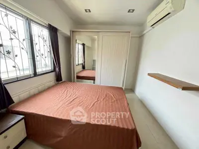 Cozy bedroom with air conditioning and mirrored wardrobe in modern apartment.