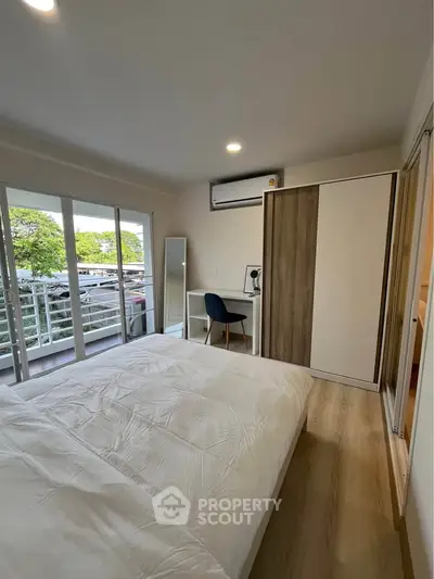 Modern bedroom with balcony access and stylish decor in a contemporary apartment.