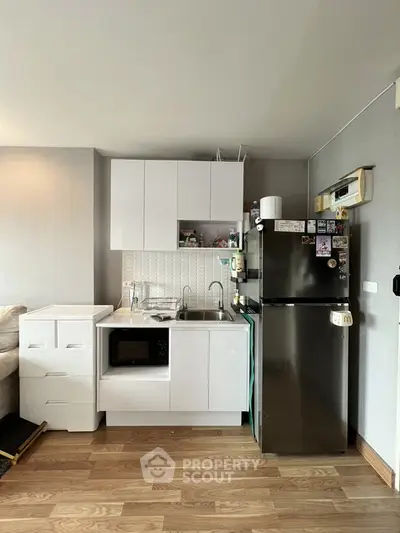 Compact kitchen with modern appliances and sleek cabinetry in cozy apartment