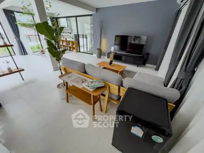 Modern living room with stylish decor, large windows, and cozy seating area, perfect for relaxation and entertainment.
