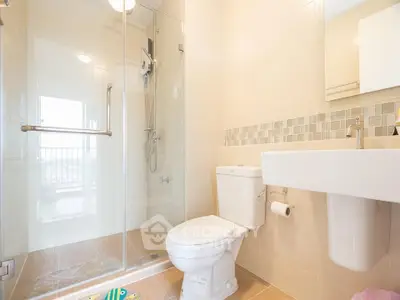 Modern bathroom with glass shower, sleek fixtures, and neutral tiles.
