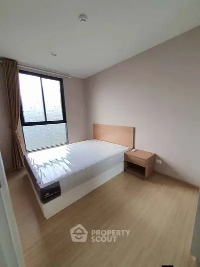 Modern minimalist bedroom with natural light and wooden flooring