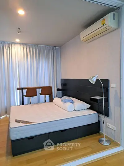 Modern bedroom with sleek design and natural light, featuring a comfortable bed and stylish decor.