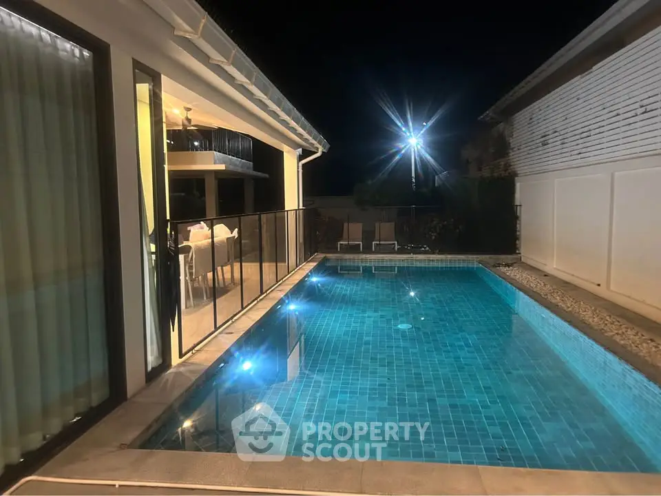 Luxurious night view of a modern home with a sparkling private pool and elegant outdoor lighting.