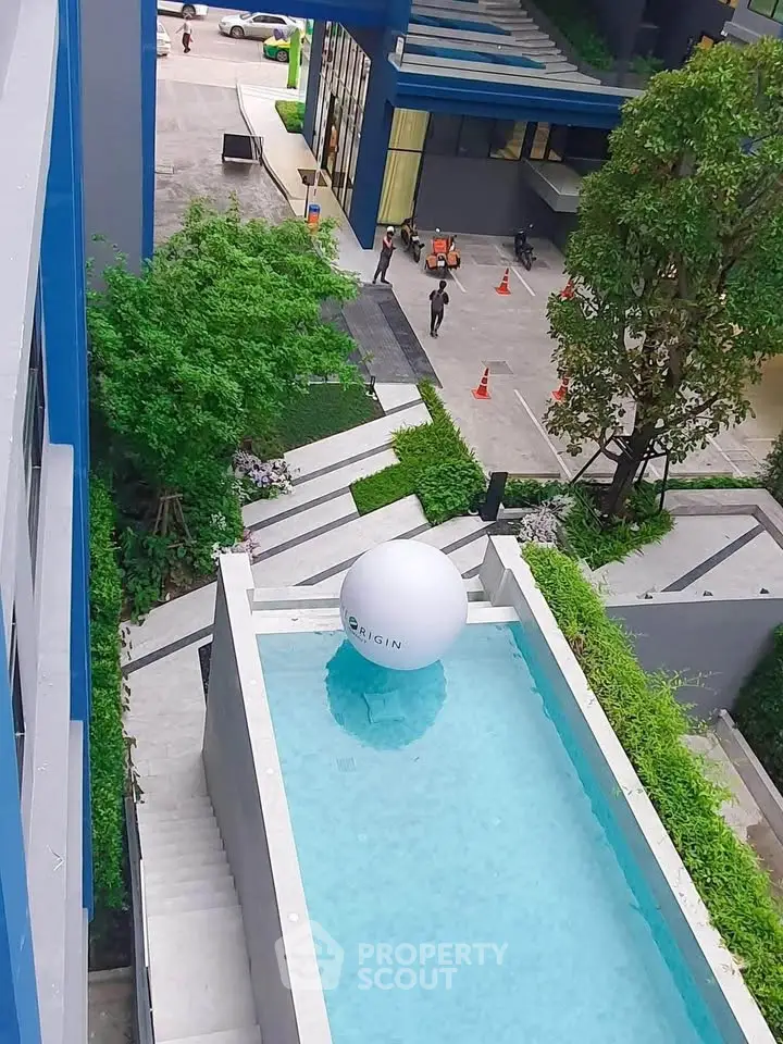 Modern apartment complex with rooftop pool and lush greenery, offering a luxurious urban lifestyle.