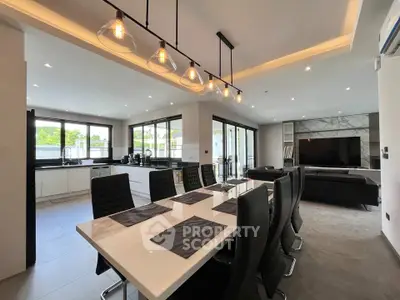 Luxurious open-plan living and dining area with modern kitchen and elegant lighting.
