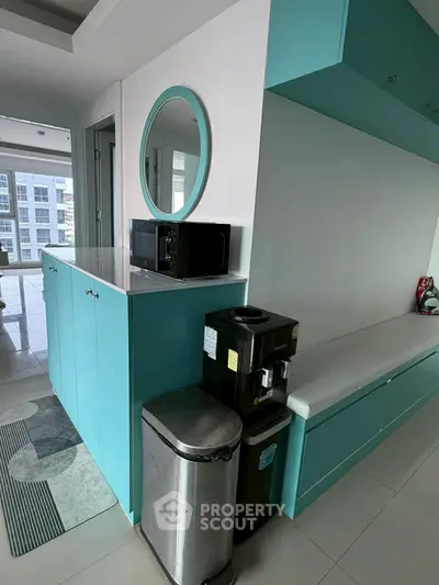 Modern kitchen with turquoise cabinets and sleek appliances in a stylish apartment