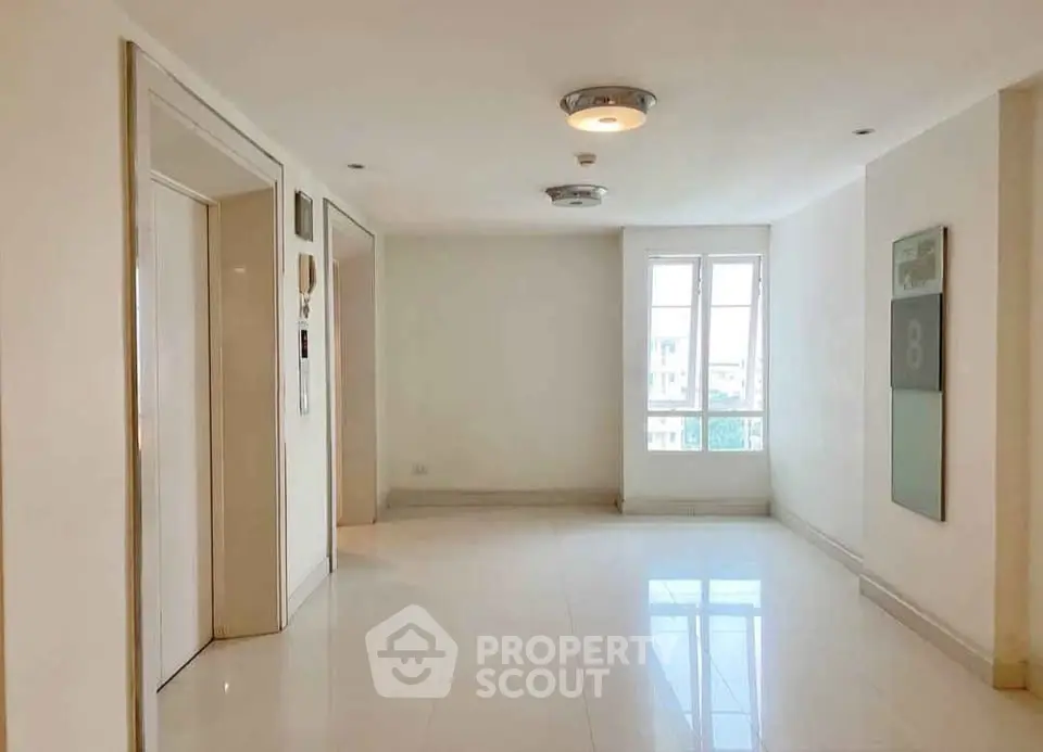 Spacious modern apartment hallway with elevator and natural light