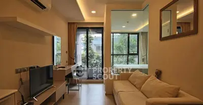 Modern living room with cozy sofa and large windows offering garden view