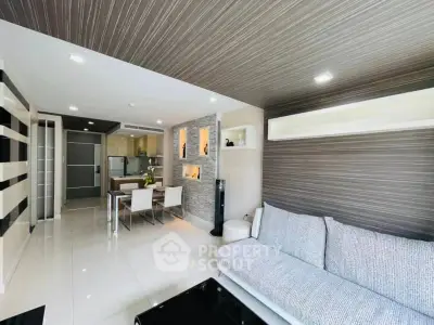 Modern living room with sleek design and open dining area, featuring stylish decor and ample natural light.