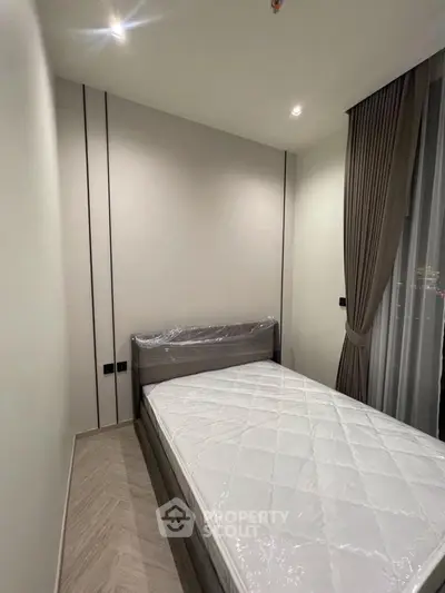 Modern bedroom with minimalist design and large window for natural light.