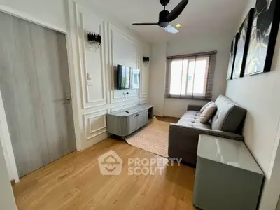 Modern living room with stylish decor, wooden flooring, and cozy seating area.