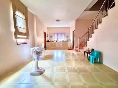 Spacious living room with tiled floor and staircase in bright home