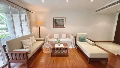 Spacious living room with elegant wooden flooring and cozy seating area, perfect for relaxation.
