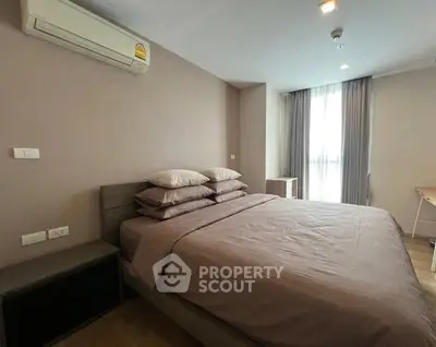 Spacious bedroom with modern decor and natural light in a stylish apartment.