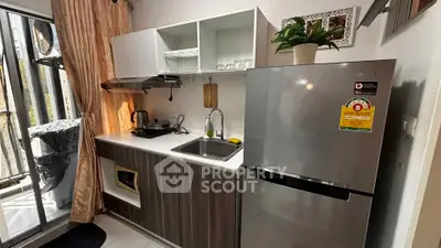 Modern kitchen with sleek appliances and open layout, featuring a large fridge and ample natural light.