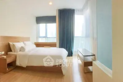 Spacious and bright bedroom with modern furnishings and large windows.