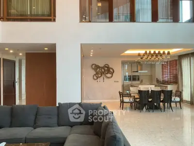 Luxurious open-plan living and dining area with modern decor and elegant lighting.