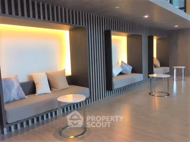 Modern shared lounge area with stylish seating and ambient lighting in a contemporary building.
