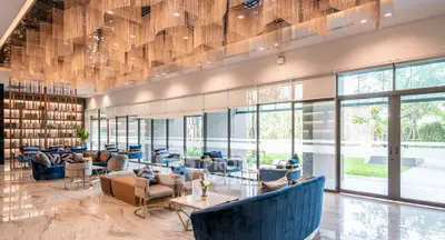 Luxurious modern living room with elegant decor and large windows offering garden views.