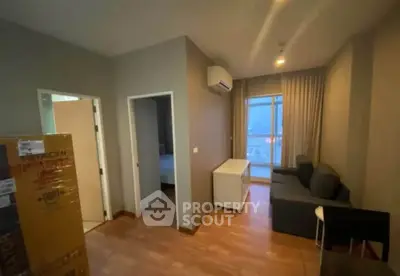 Cozy living room with modern furniture and air conditioning, featuring a view through large windows.