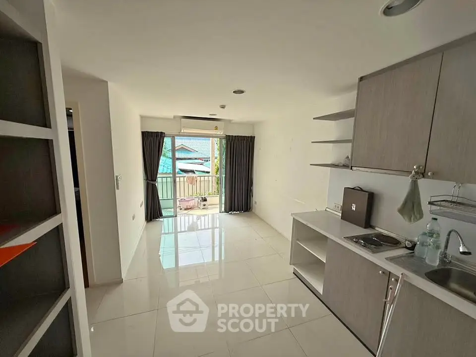 Modern open-layout kitchen with sleek cabinetry and balcony view, perfect for urban living.
