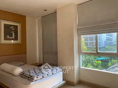 Bright bedroom with large window and modern decor in urban apartment