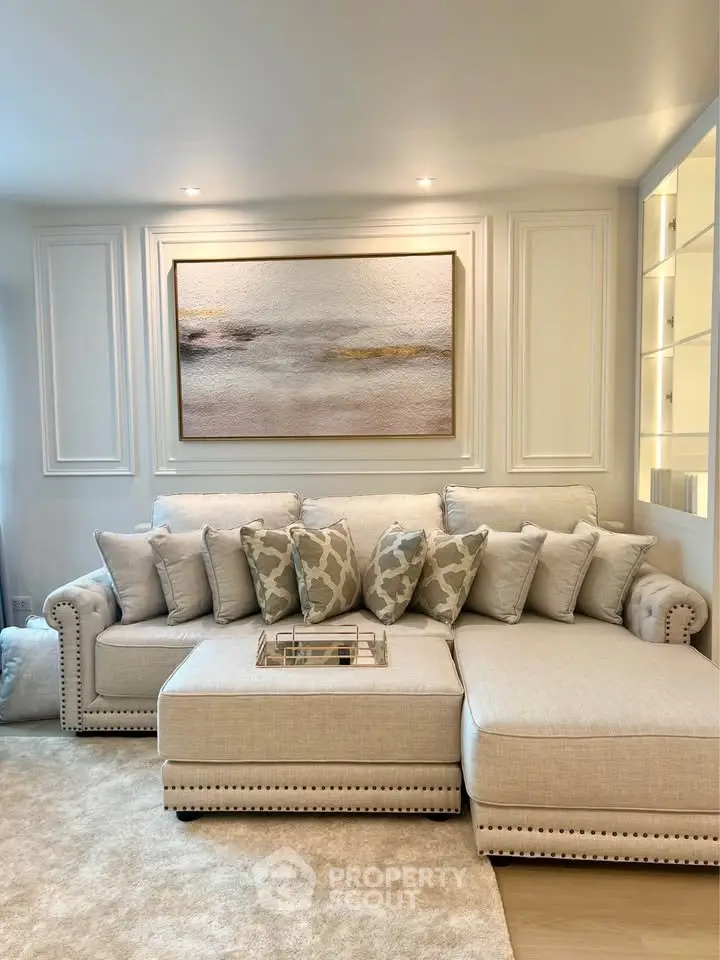 Elegant living room with plush sectional sofa and stylish wall art, perfect for modern comfort and luxury.