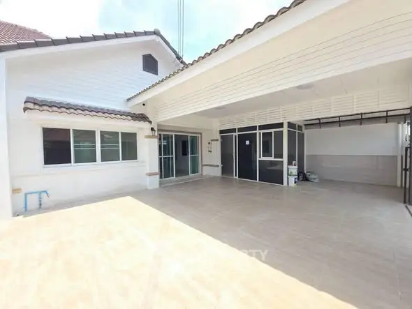 Spacious modern home exterior with covered patio and tiled flooring, perfect for family gatherings.