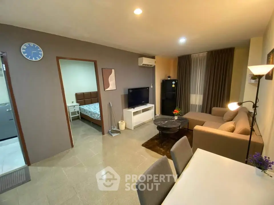 Modern living room with cozy sofa, dining area, and view into bedroom, perfect for urban living.