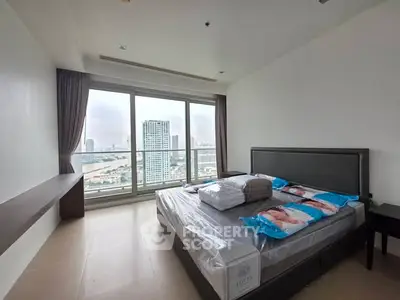Spacious bedroom with large windows offering stunning city views in modern apartment.