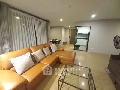 Spacious modern living room with leather sofa and glass coffee table in a stylish apartment.