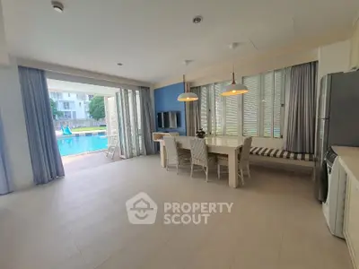 Spacious open-plan living area with pool view, modern dining set, and natural light.