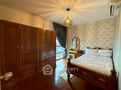 Charming bedroom with elegant wooden furniture and large window offering natural light.