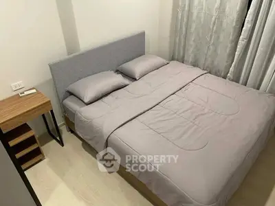 Cozy bedroom with modern design featuring a comfortable bed and stylish side table, perfect for relaxation.