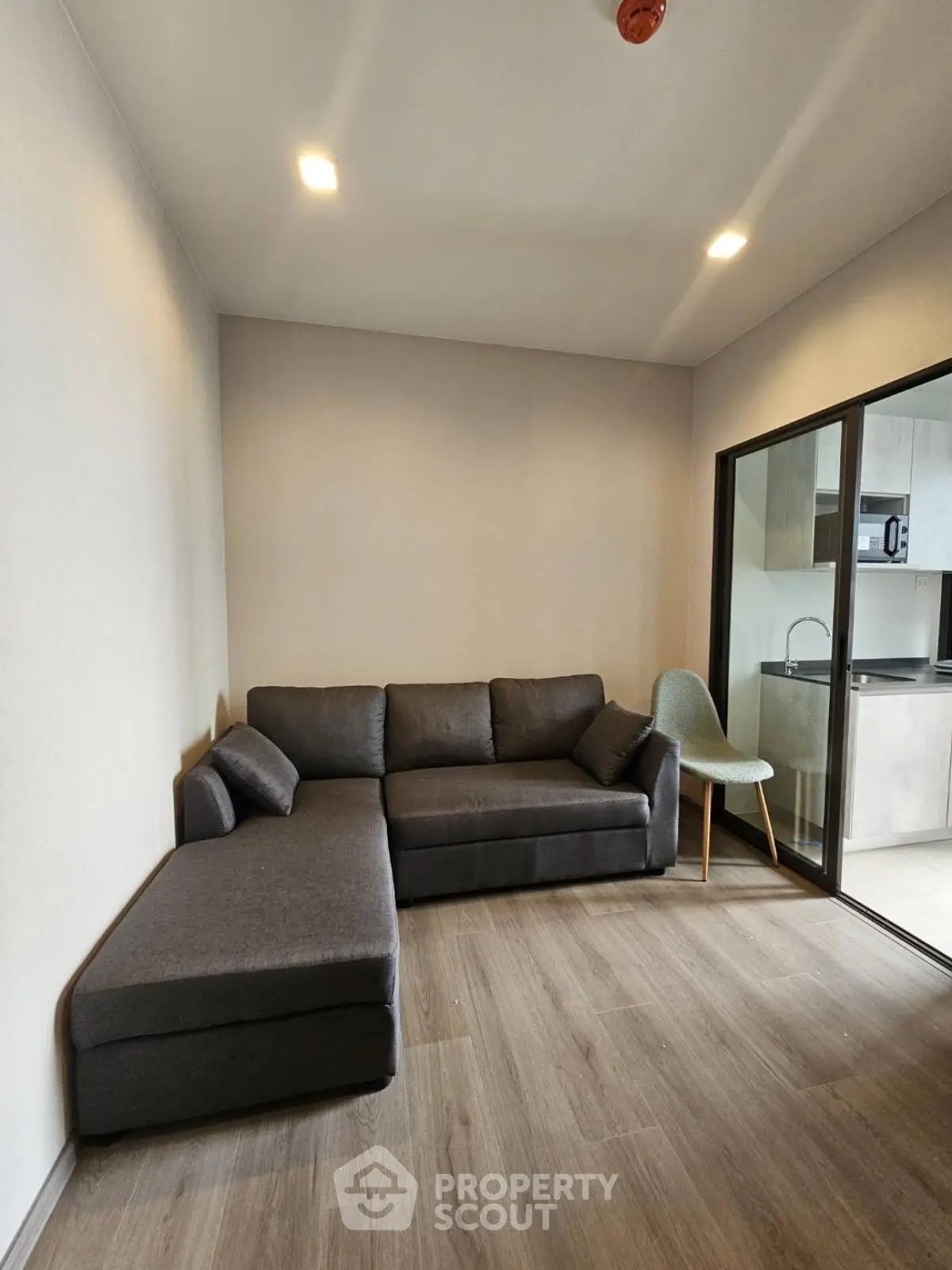 Modern living room with sleek sofa and open kitchen view