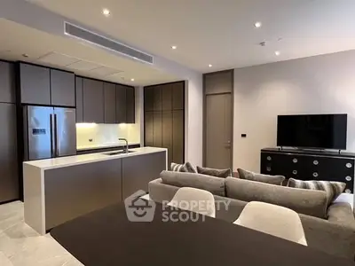 Modern open-plan kitchen and living room with sleek design and neutral tones.