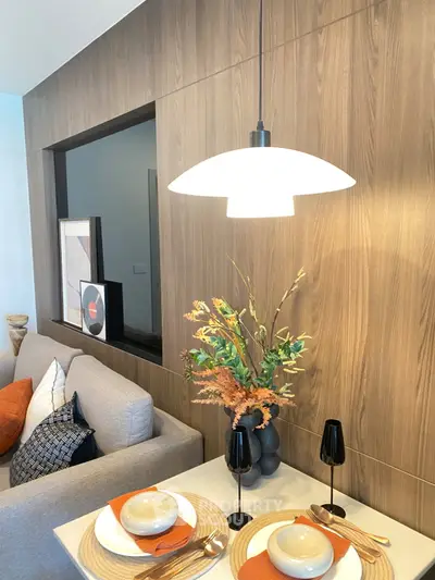 Modern living room with stylish decor, featuring a cozy sofa, elegant lighting, and a decorative wall panel.
