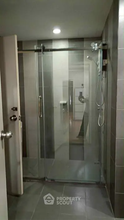 Modern bathroom with glass shower enclosure and sleek tile design.