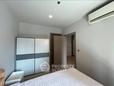 Modern bedroom with sleek wardrobe and air conditioning unit, perfect for comfortable living.