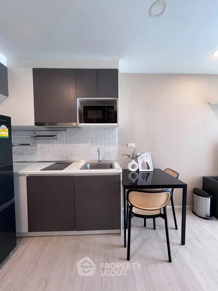 Modern kitchen with sleek cabinetry and dining area in stylish apartment