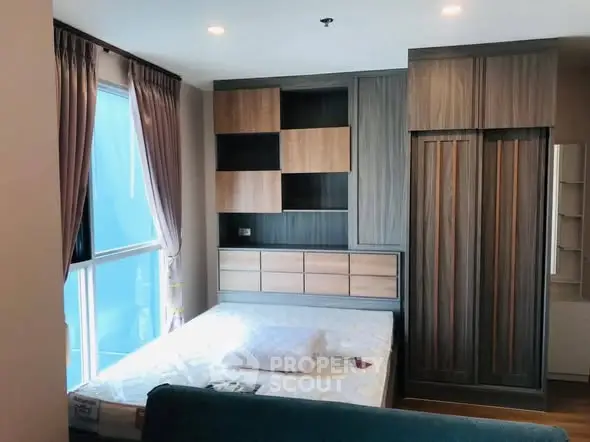 Modern bedroom with stylish wooden wardrobe and large window for natural light.