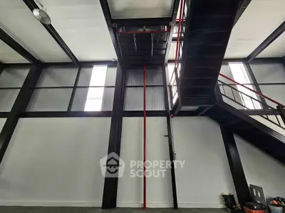 Modern industrial interior with high ceilings and metal staircase
